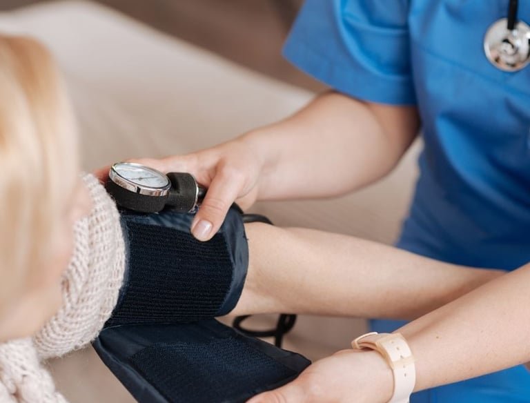 Nurse taking a patient's blood pressure at home